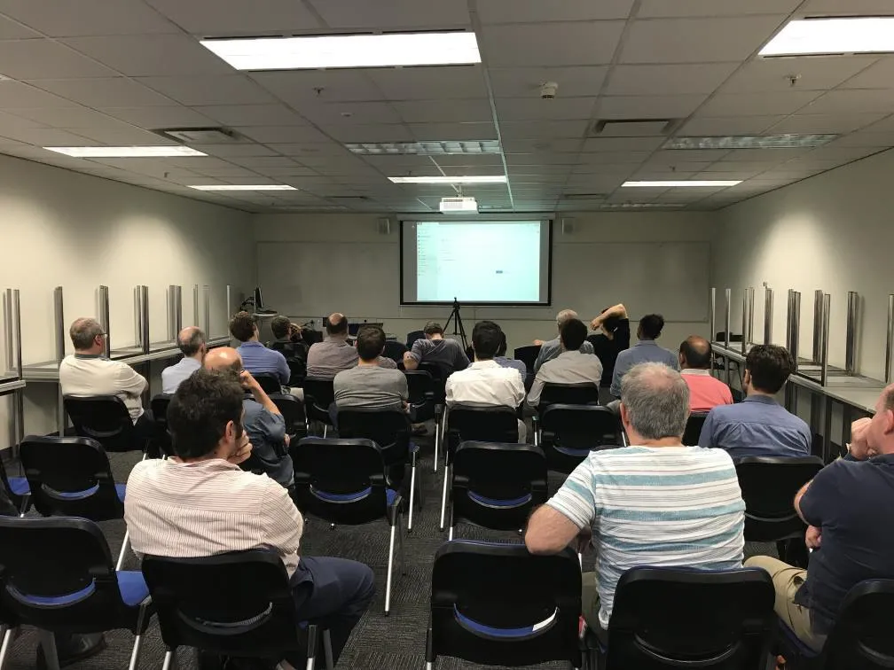 People seated, watching a presentation