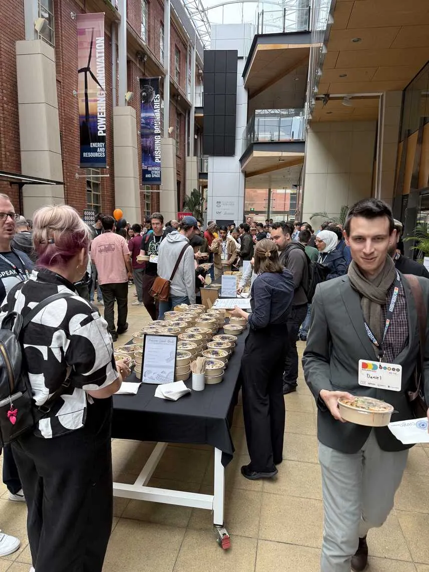 Lunchtime in the atrium. Lunch bowls are on a table for attendees to grab