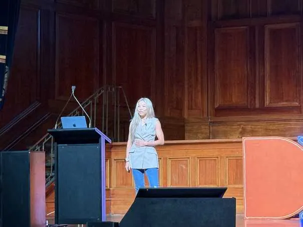 Sreyna Rath standing on stage presenting