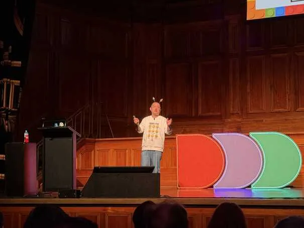 Daniel on stage, with big DDD logo to his right