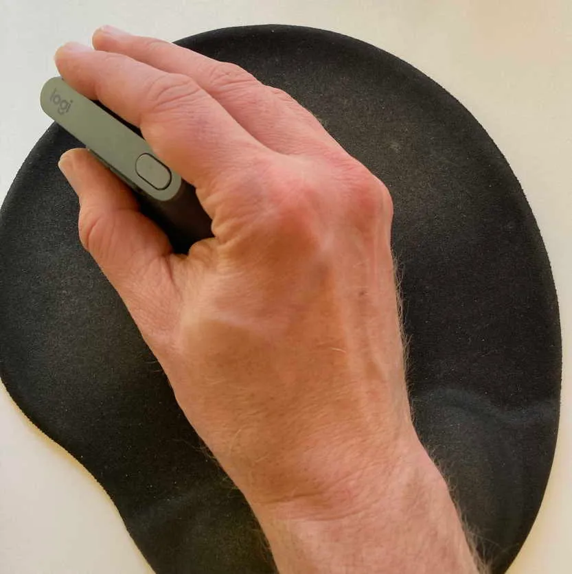 Mouse being held in a hand, sitting on a mouse mat