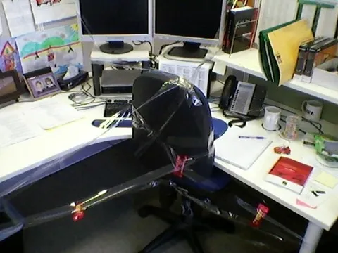 Office desk with sticky tape over chair, desk and monitors