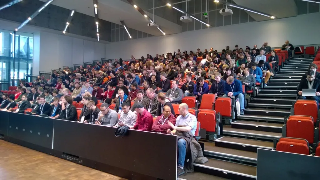 Attendees in main auditorium waiting for start
