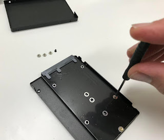 Unscrewing mounting board from drive enclosure