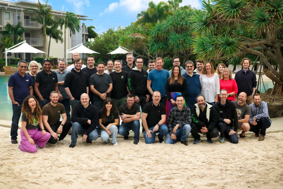 Group photo of almost all the SixPivot staff, standing in front of a swimming pool