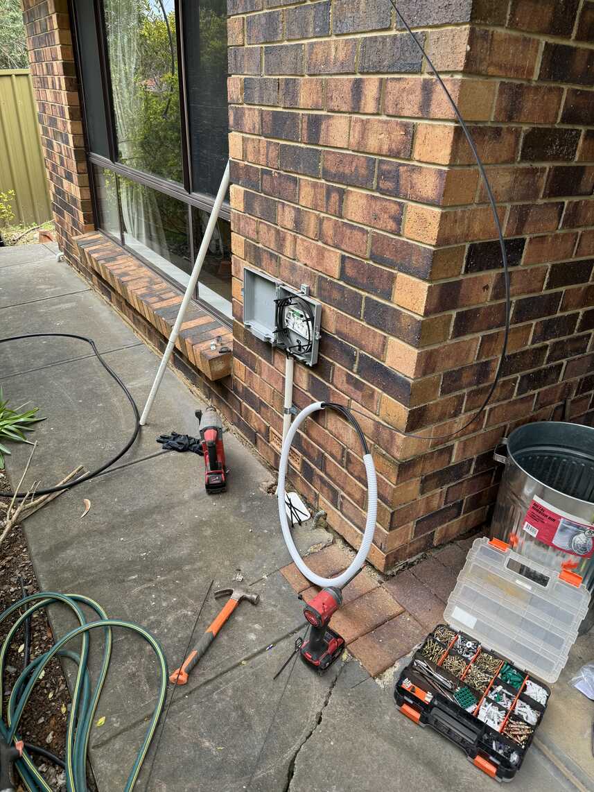 NBN utility box being installed on exterior wall