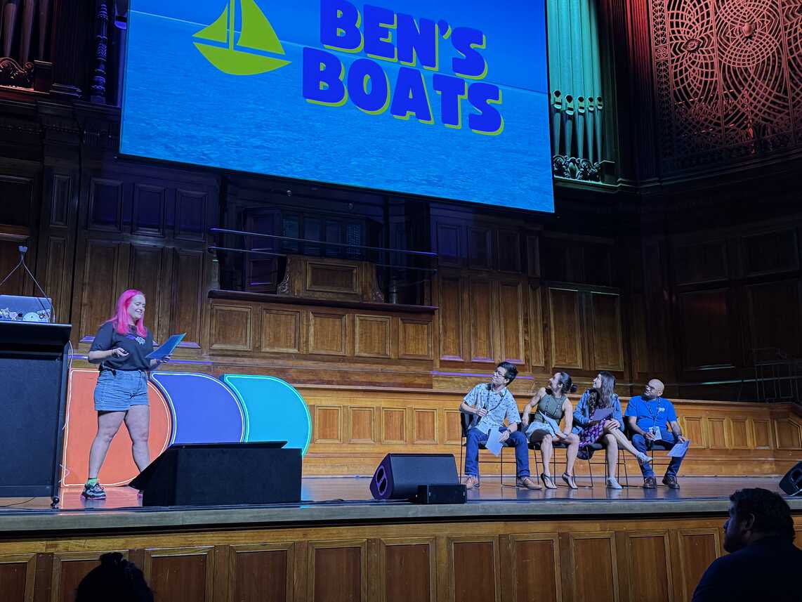 Kirsty McDonald on stage with four seated volunteers